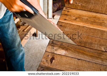 Moving Shot of The Carpenter Sawing Down Wood, Cutting, Making Furniture by Hand / Concept and Idea of Workshop Carpentry Business and Carpenter Wood Work. Real Still Life Style.