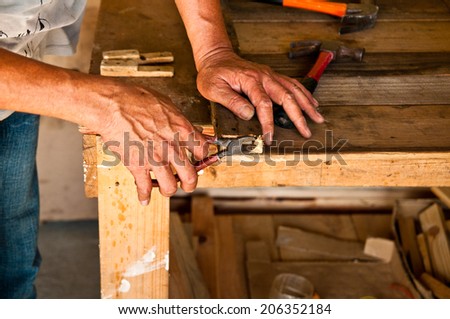 The Carpenter Use Pliers or Pincer to Get a Nail from Wood, Making a Furniture / Concept and Idea of Carpentry Business and Carpenter Wood Work.