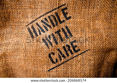 Vintage Burlap Bag with Handle with Care word text screen for Concept and Idea of Food, Art, Object, Kitchen Background and Textured, Country Rustic Still Life Style.