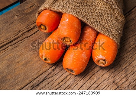 Pack of Fresh Harvest Carrot with Vintage Burlap Bag on Wood Table Background, Concept and Idea of Food Cook Rustic Still life Style.