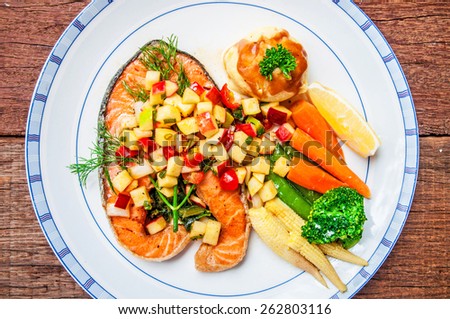Grilled Salmon Steak with Apple Salsa Sauce, serving side with Spinach, Mash Potato, Lemon, Butter Vegetable. Concept and Idea of Fusion Food, Cooking Style. / on wood table Background. Top view.