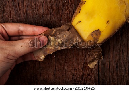 Hand Peeling Potato Skins, Fresh Hot Boiled, on Wood Table Background, Concept and Idea of Food Cook Rustic Still life Style. Close up.