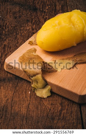 Fresh Hot Boiled Whole Potato Peeled Skins on Wood Cutting Board, Wood Table Background, Concept and Idea of Cooking, Food Rustic Still life Style.