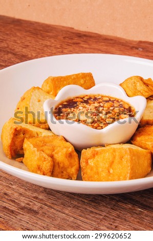 Fried Tofu, Crispy outside and Soft inside. Dip with Sweet Sour Tamarind Sugar Chilli Sauce, Top with Peanut Crusted. Wood Background, Rustic Still Life Style, Fresh Homemade Healthy Cooking Idea.