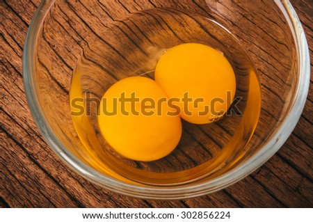 Fresh Eggs, Twin Egg Yolk in Glasses Bowl on Wooden Table Background, Country Rustic Style. Concept Idea of Cooking and Baking.