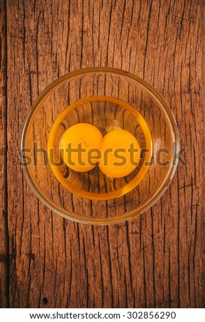 Fresh Eggs, Twin Egg Yolk in Glasses Bowl on Wooden Table Background, Country Rustic Style. Concept Idea of Cooking and Baking. Top View Vertical.
