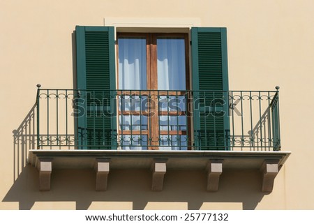 Green balcony on the yellow wall building exterior Italy