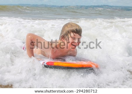 Young boy body boarding in white water