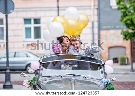 Young couple in the car on their wedding day
