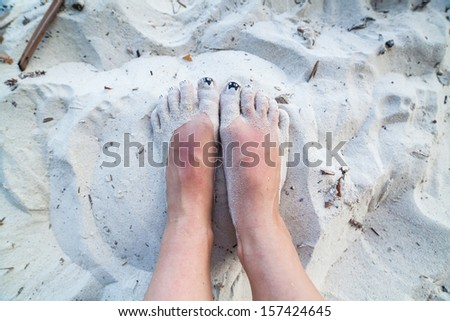 Feet with cat nails in the sand