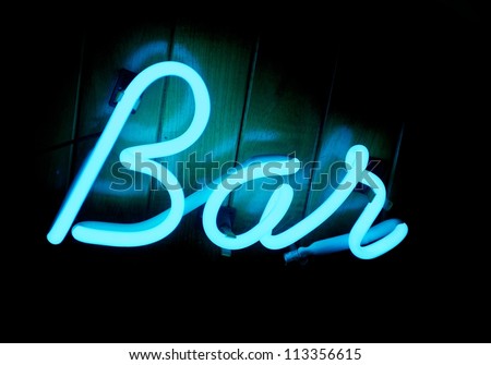 A cool blue lit neon bar sign on a teak wood paneled wall