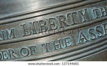 Closeup shot of the lettering on a replica of the Liberty Bell. Focusing on the word \