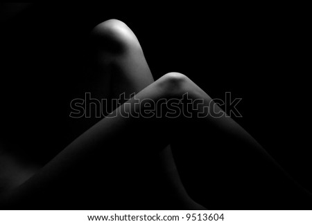 Female legs on black background - soft light