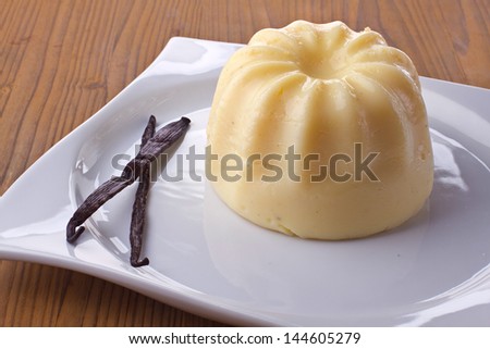 Vanilla pudding in a plate on a wooden background