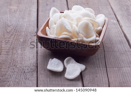 Shrimp chips in a bowl on a wooden background