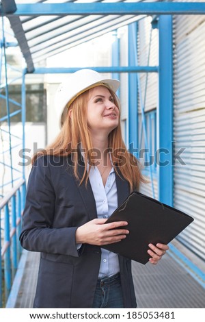 Woman architect holding folder and looking ahead