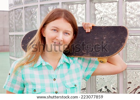 Woman with skateboard wearing plaid shirt