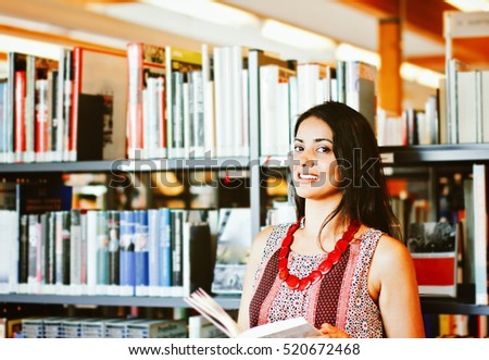 Indian student holding a book at the library
