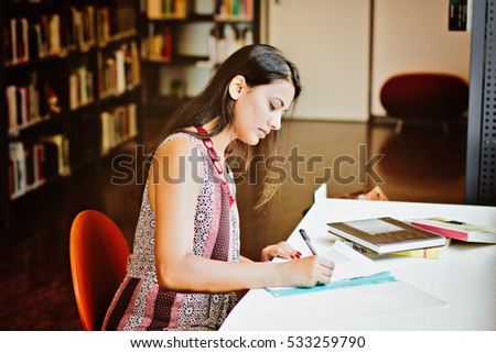 Indian student sitting at the table and writing