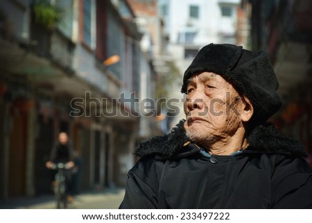 An old man sat in the street to see the scenery