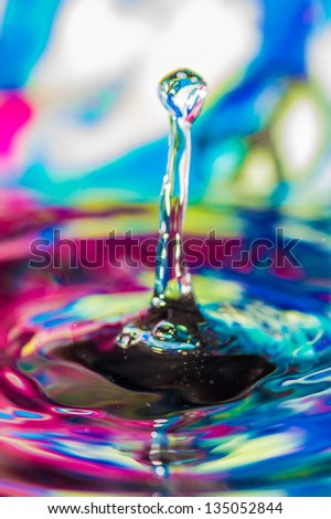 Colorful tower waterdrop with a peace sign in the de-focused background reflected in a water bubble