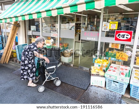 Kyoto, Japan - August 12 2013: A senior Japanese woman enters a supermarket in Kyoto. Japan has the most aging population in the world.