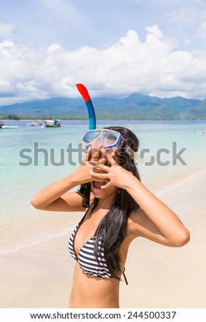 Young Asian woman wearing a snorkel and a mask on a beach in Gili island near Bali in Indonesia