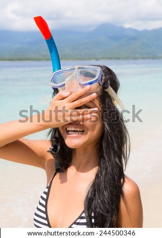 Young Asian woman wearing a snorkel and a mask on a beach in Gili island near Bali in Indonesia