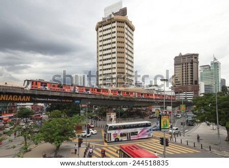 Kuala Lumpur, Malaysia - December 18 2014: Buses pass through an intersection with an elevated train line above it in Kuala Lumpur Pudu district.
