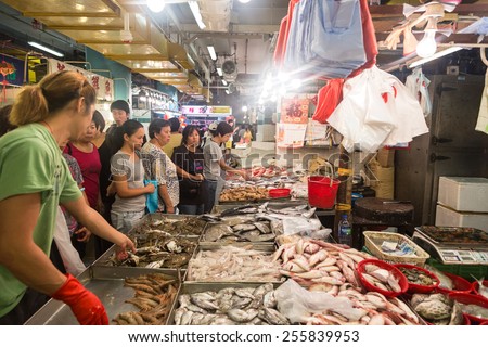 Hong Kong, Hong Kong - September 14 2014: People stroll around various seafood stalls in an indoor fish market in Hong Kong island.