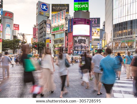 Tokyo, Japan - August 18 2013: A large crowd captured with blurred motion walk through the world famous Shibuya crossing in Tokyo.