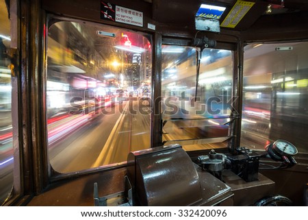 Inside a Tram car rushing through Hong Kong island streets at night. WIde angle and long exposure are used.