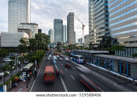Traffic captured with blurred motion along Jakarta main avenue, Jalan Thamrin, in the business district at dusk in Indonesia capital city.
