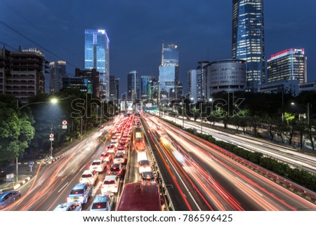 Light trails from heavy traffic along the Gatot Subroto highway in the heart of Jakarta business district at night. Jakarta is Indonesia capital city and the largest in Southeast Asia.