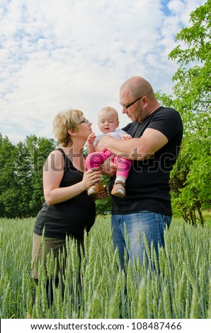 Pregnant parents with their one year old baby girl