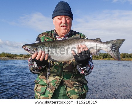 Senior fisherman with caught salmon (Kamchatka, Russia)