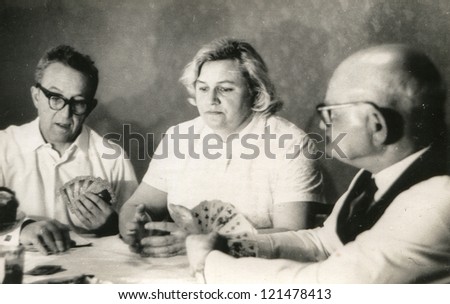 Vintage photo of elderly man playing cards with his daughter and son-in-law (sixties)
