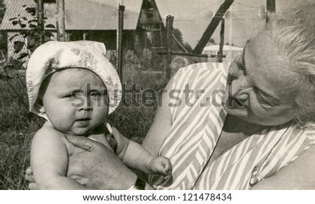 Vintage photo of grandmother with her baby granddaughter (1982)