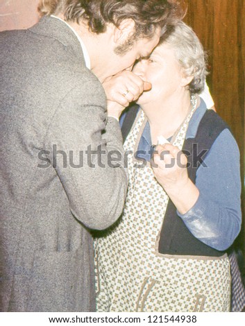 Vintage photo of grandmother and grandson blessing each other and sharing Christmas wafer during the Christmas Eve Vigil (seventies)