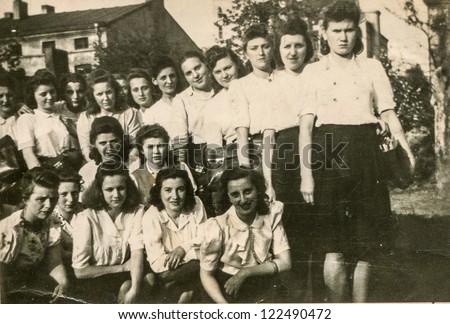 LODZ, POLAND, CIRCA 1937 - Vintage photo of group of female high school pupils in uniforms, posing outdoor, Lodz, Poland, circa 1937