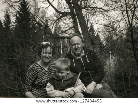 Vintage photo of parents with little son in forest (early eighties)