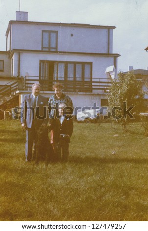 Vintage photo of parents with little son and a dog, early eighties
