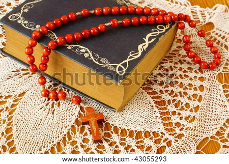 Vintage bible with wooden rosary beads