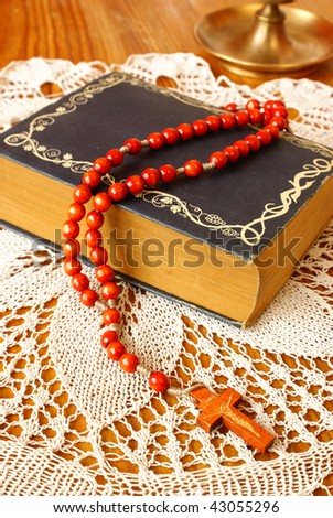 Vintage bible with wooden rosary beads