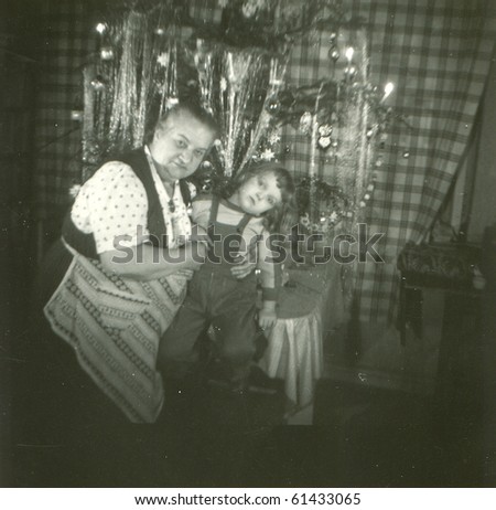 Vintage photo of grandmother and granddaughter under Christmas tree (fifties)