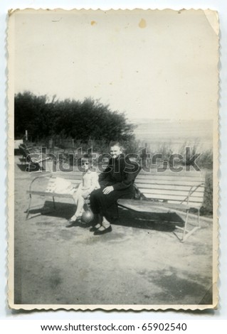 Vintage photo of grandmother with her granddaughter on bench