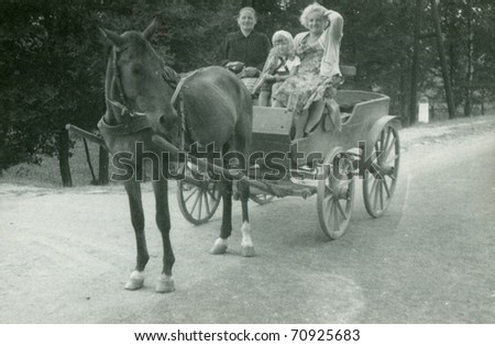 Vintage photo of family traveling in horse-drawn carriage (sixties)