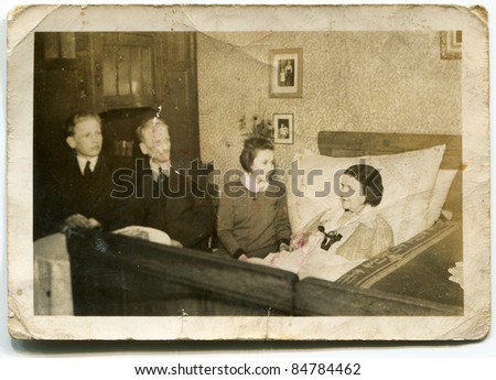 Vintage photo of family visiting bedridden grandmother