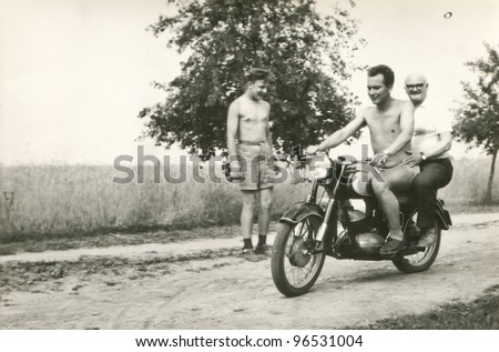 Vintage photo of elderly father and son riding a motorcycle