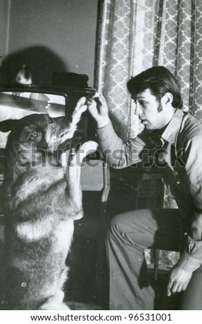 Vintage photo of young man training a dog (sixties)